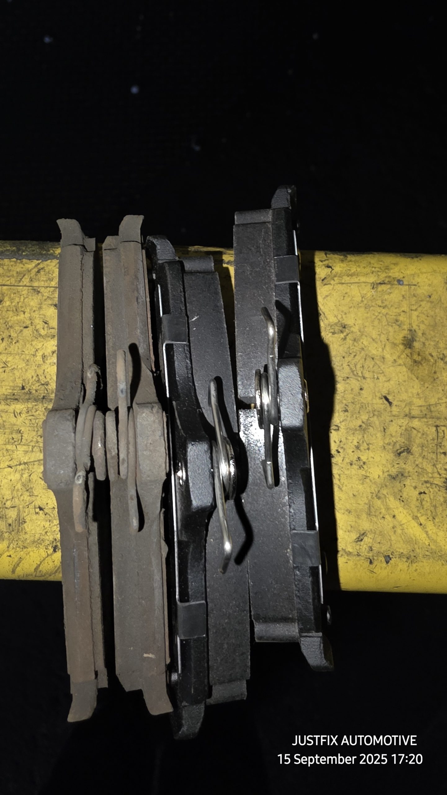 A side by side compression of worn brake pad and a set of new automotive brake pads at Justfix Automotive