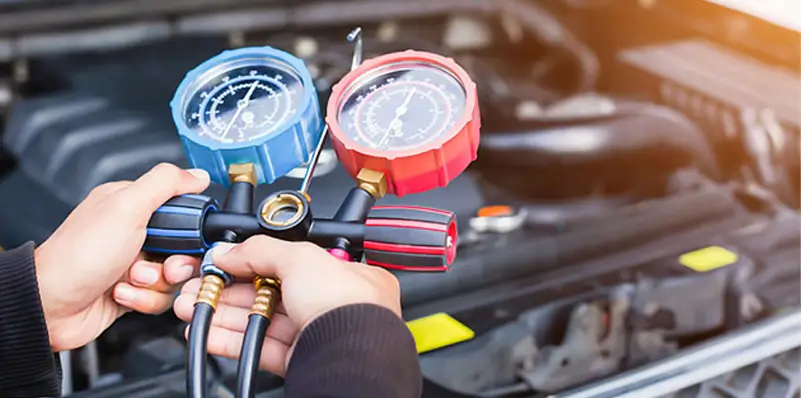 Man holding car air conditioning gauges to test/diagnosis aircon system